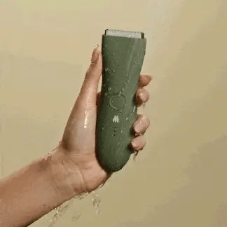 hand holding waterproof hair trimmer under running water